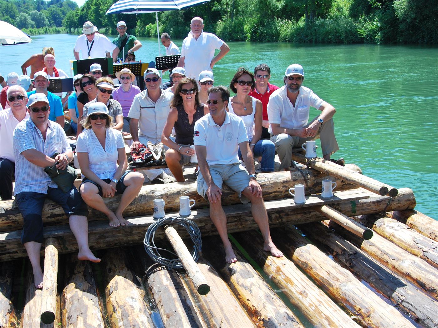 Gruppe auf einem Holzfloß bei einer Floßfahrt auf der Isar